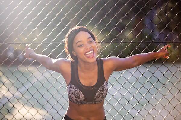 Woman Standing Besides Chain Link Fence 